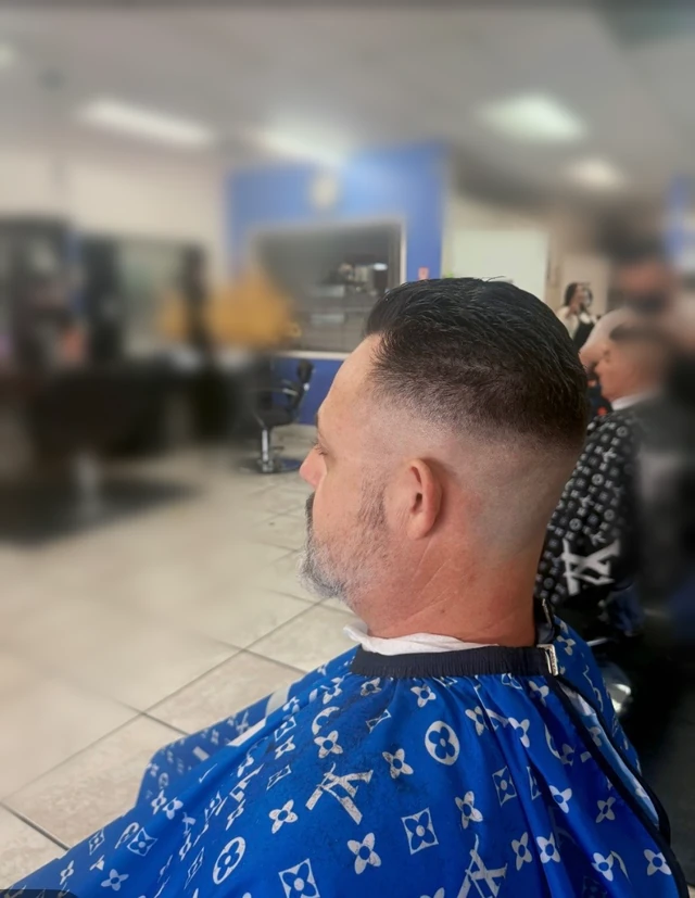 Short combed-back haircut with faded sides and nape, viewed from the rear side.